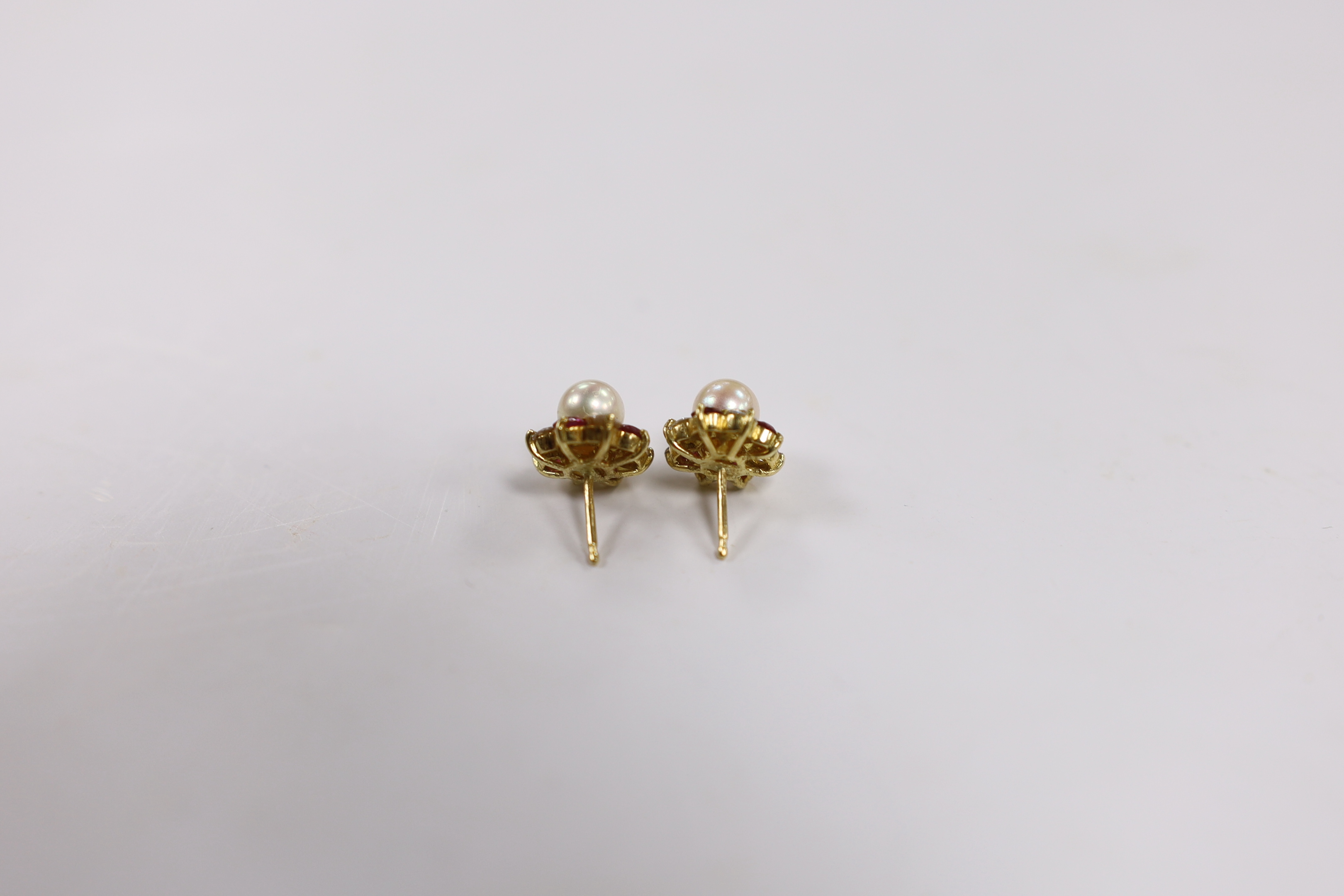 A pair of yellow metal, cultured pearl, ruby and diamond set flower head cluster ear studs (lacking butterflies), 11mm, gross weight 4.2 grams.